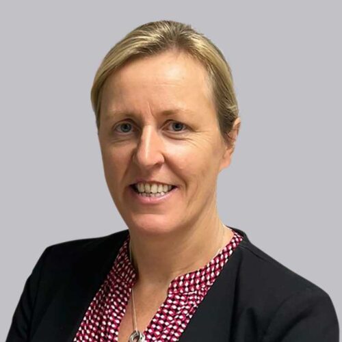 Julie McCleary in dark suit and patterned shirt.