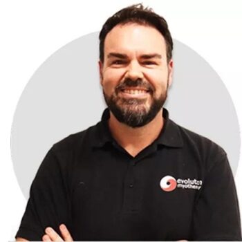 Mark, with dark hair and a beard, faces camera with big smile in black polo shirt with business logo in orange and white